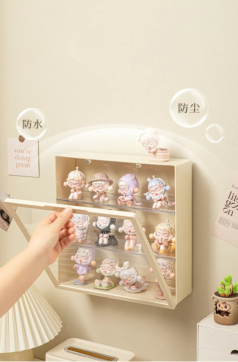 A hand places collectible dolls into a wall-mounted dustproof display case with protective labels.