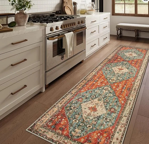 A vintage bohemian trellis runner rug with geometric patterns in orange, blue, and cream sits on a wooden floor.