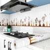 A white kitchen splashback featuring decorative floral stickers and a large stainless steel extractor hood.