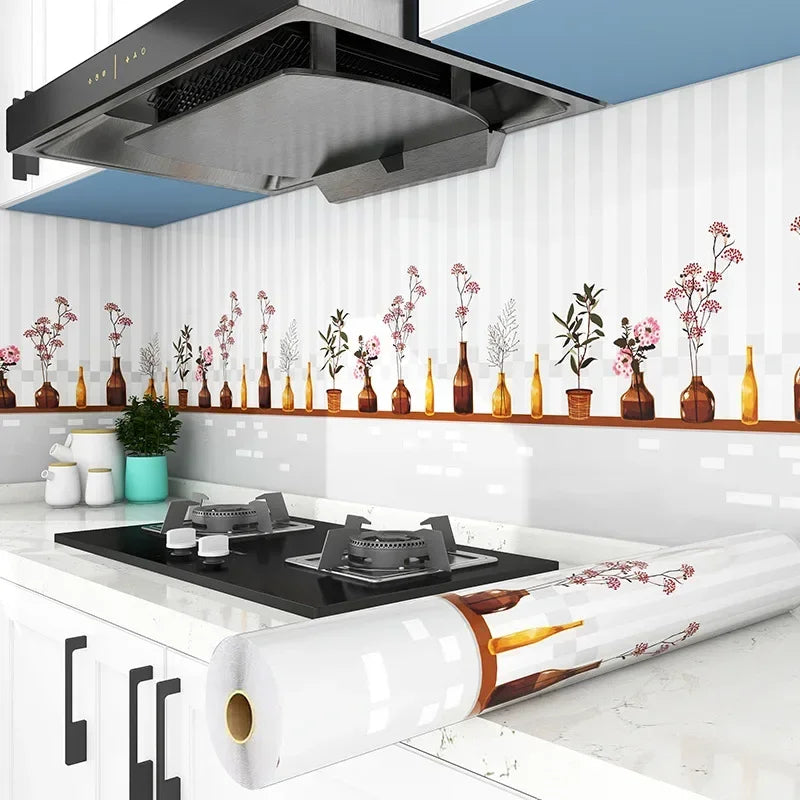 A white kitchen splashback featuring decorative floral stickers and a large stainless steel extractor hood.