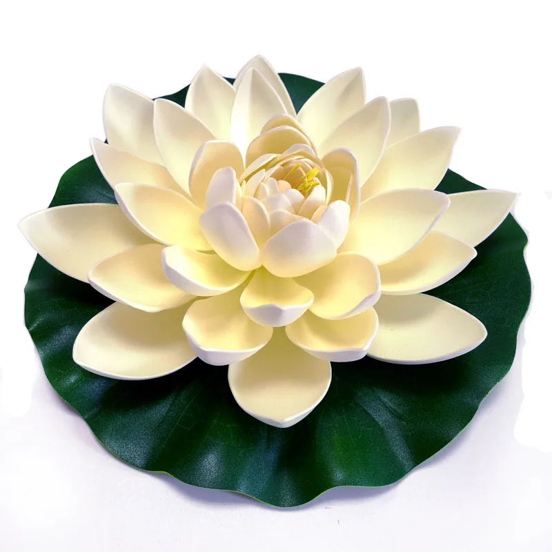 A lifelike, pale yellow and white lotus flower rests on a dark green leaf for pond or garden decor.