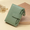 A light green genuine leather RFID blocking bi-fold wallet resting on a wooden surface.