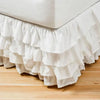 White ruffled bed skirt wrapping around a mattress to hide under-bed space