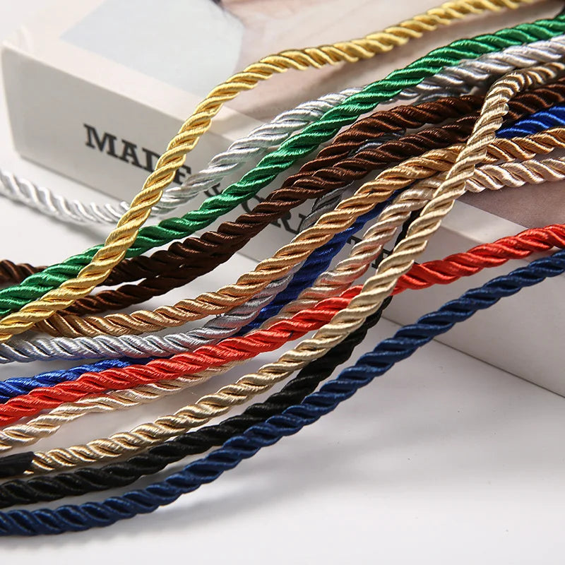 Nahaufnahme verschiedener bunter polyestergeflochtener Schnüre, darunter gold, weiß, grün, braun, blau und rot.