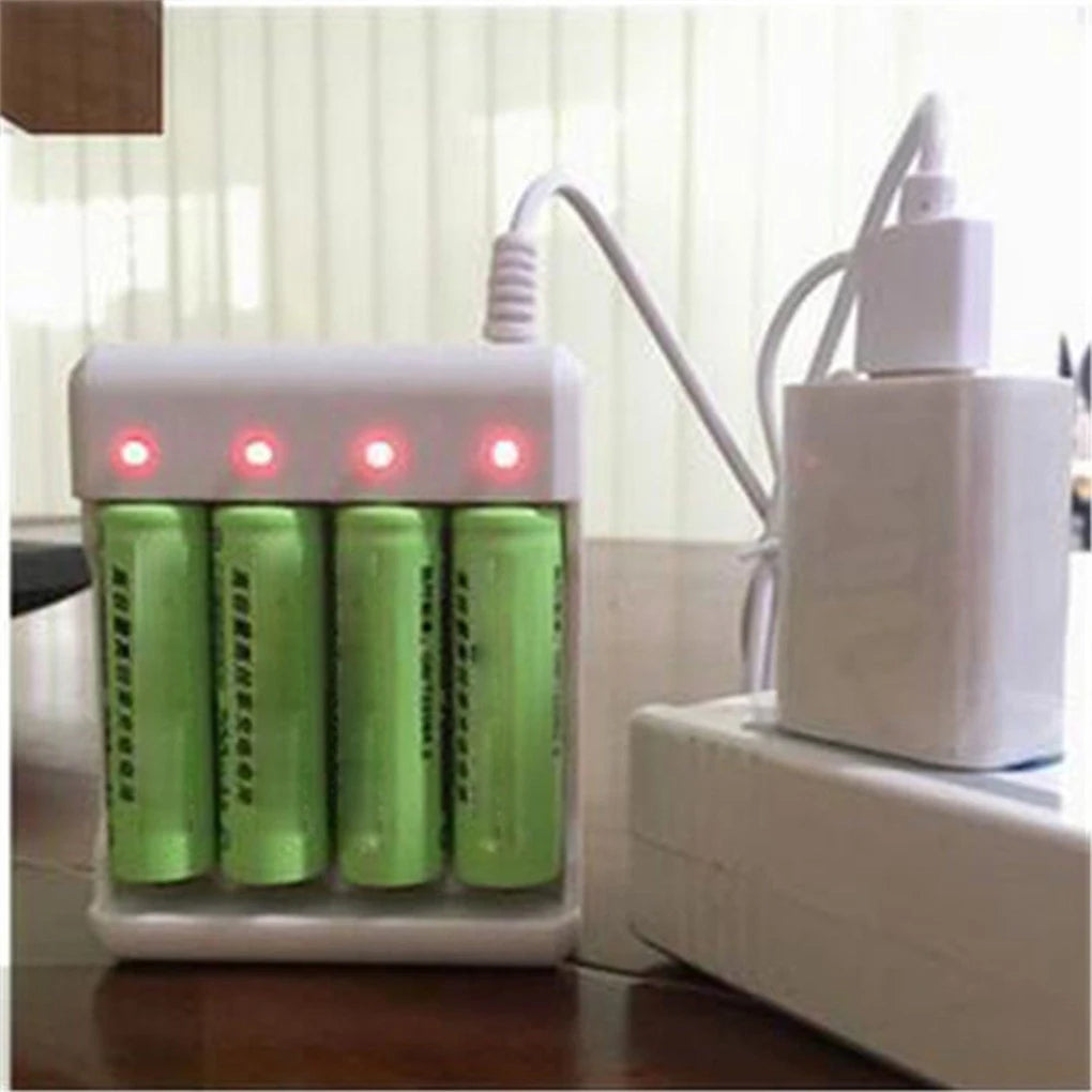 A white USB fast battery charger device with three green rechargeable batteries inserted, resting on a wooden surface.