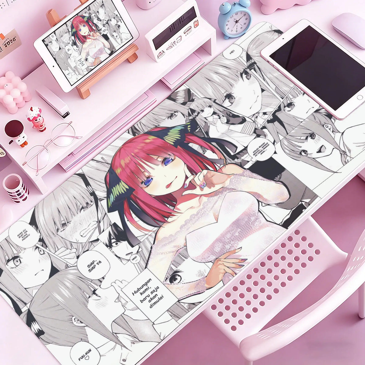 A pink and black anime-themed mouse pad or desk mat featuring characters and artwork.