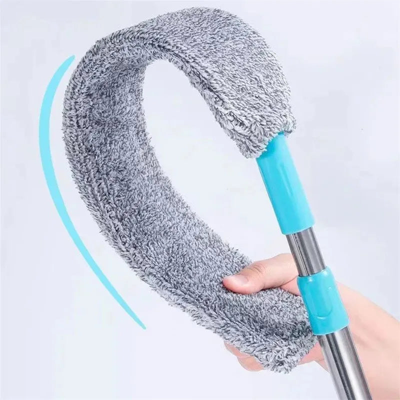 A hand holds a telescopic microfiber duster with an extendable handle, showing the fuzzy cleaning head.