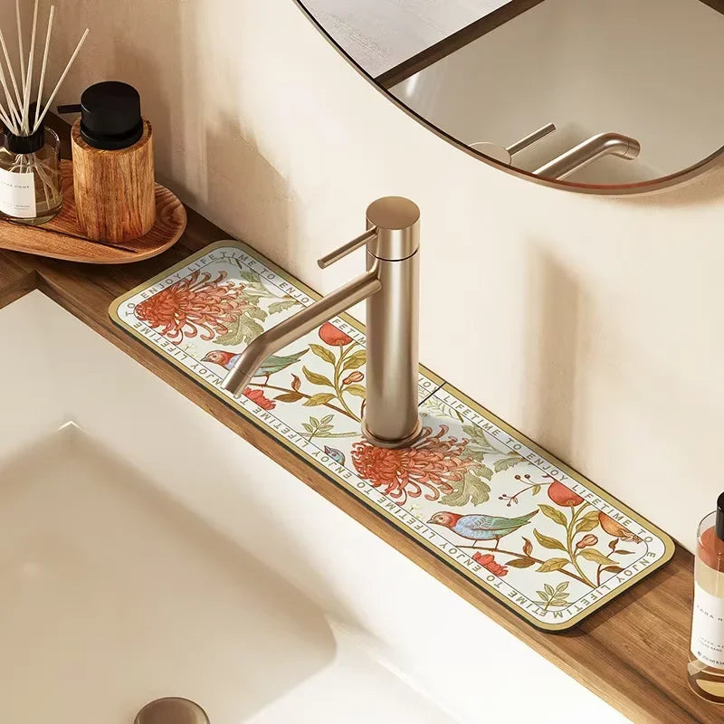 A modern metal faucet mat with a floral design is placed on a wooden bathroom counter.