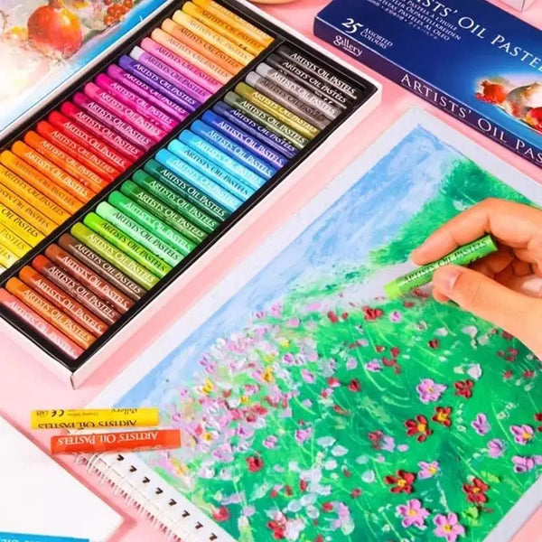 Une main applique des pastels à l'huile verts et roses sur une toile, entourée d'un jeu de pastels à l'huile solubles dans l'