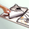 A hand is placing a white liner into a square gas hob protector pan.