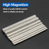 A collection of silver neodymium disc magnets arranged in a diagonal line on a dark surface.