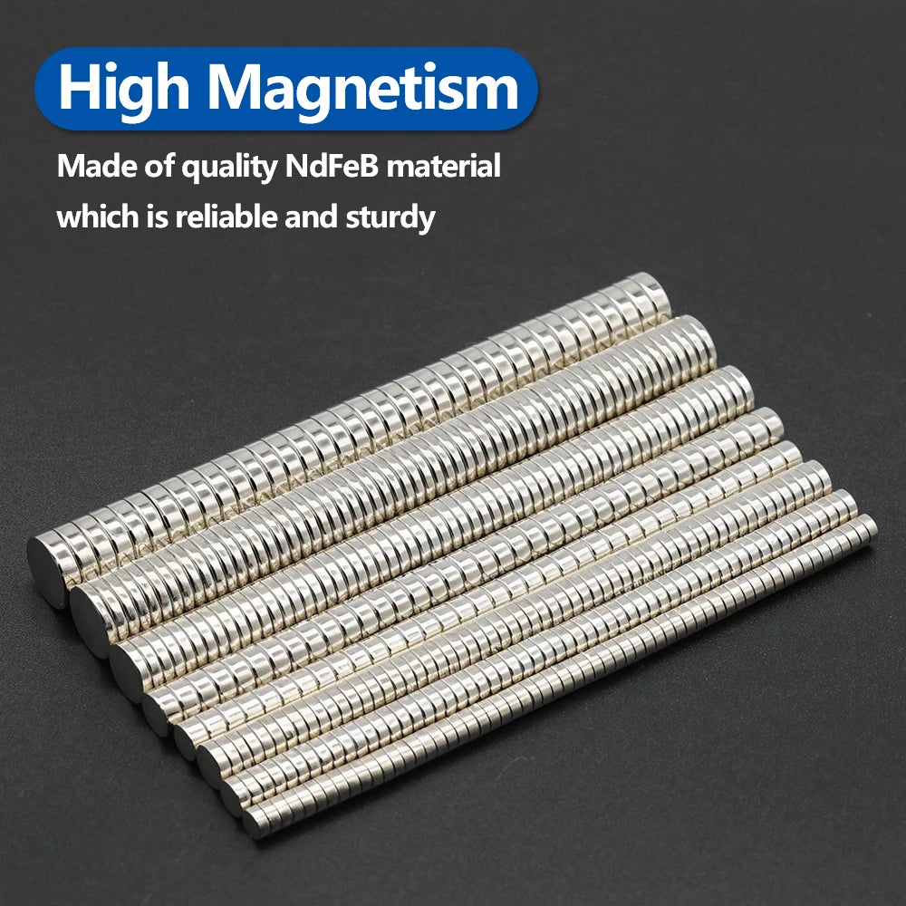 A collection of silver neodymium disc magnets arranged in a diagonal line on a dark surface.