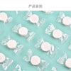 A flat lay of several clear plastic packets containing white portable compressed cleansing towels on a light blue surface.