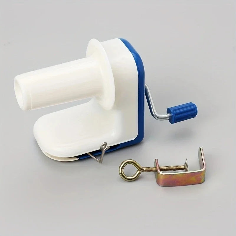 A white and blue compact hand-operated yarn ball winder tool with a metal clip attached.