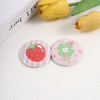 A set of playful tinplate pins featuring strawberry and clover designs on a white background.