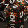 A close-up of a black resin polyhedral die with the number 9, reflecting colorful light on a dark surface.