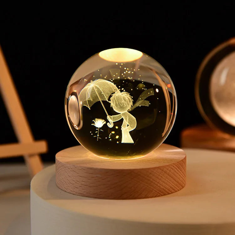 A laser engraved crystal ball night light with a golden silhouette of a figure on a wooden base.