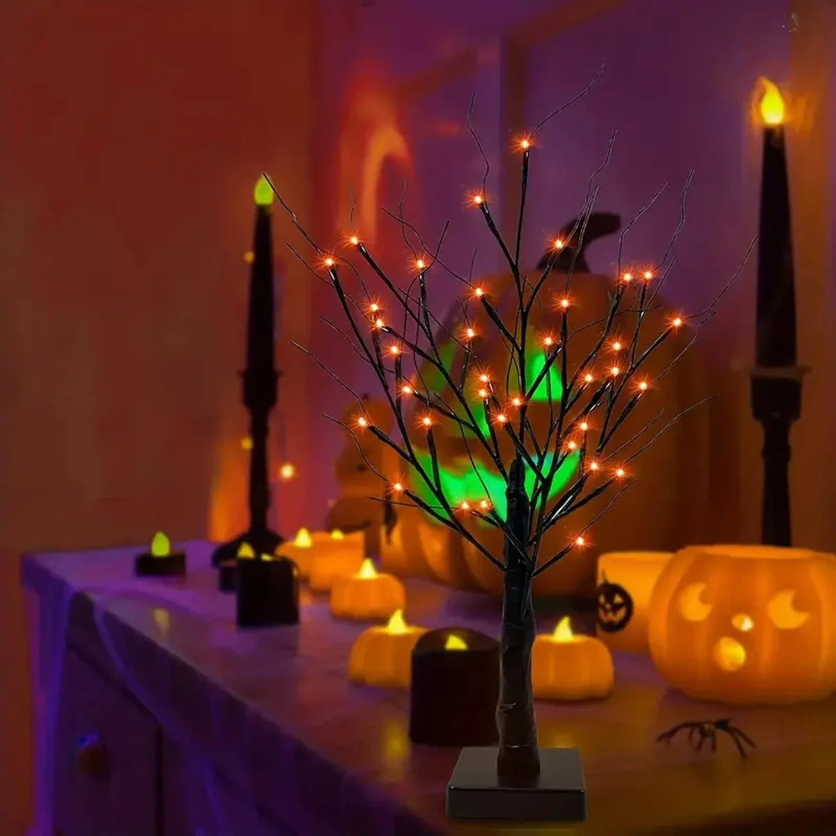 An LED Halloween birch tree decorated with orange and purple lights on a table.