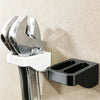 A silver wrench organizer rack with double slots is mounted on a wall, featuring a white holder and a black storage piece.