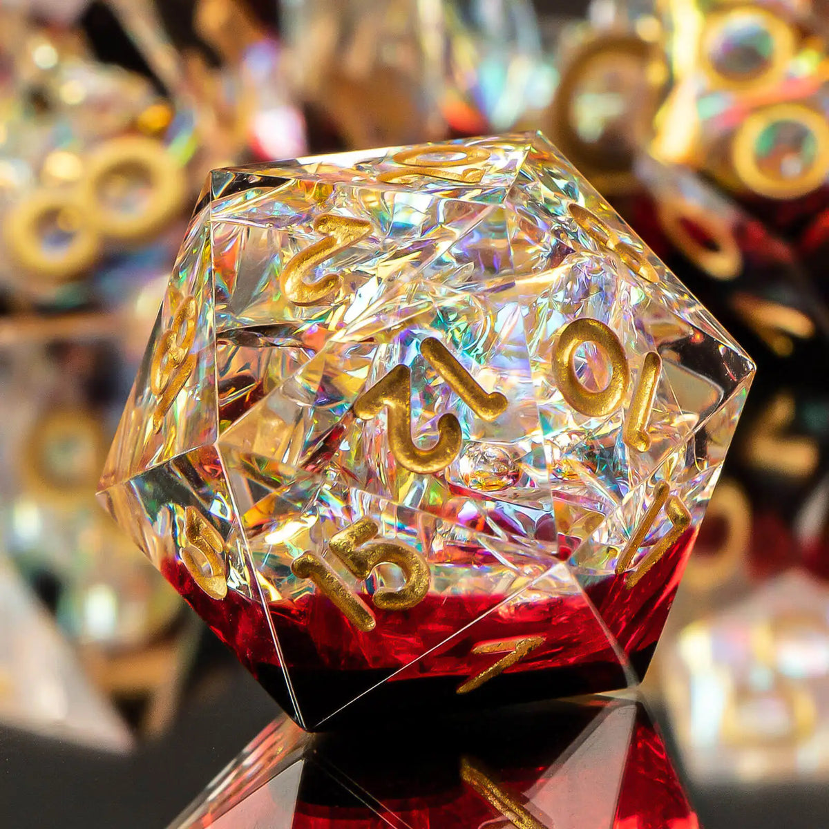 A clear, multifaceted resin polyhedral die with gold markings rests on a reflective surface.