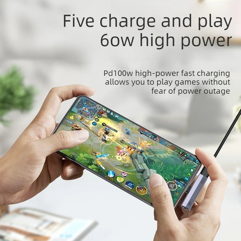 A hand holds a smartphone displaying text about five charge and play 6ow high power features.