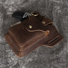 A brown genuine leather waist bag with multiple pockets and a metal clip is shown on a gray textured background.