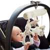 A baby is holding a soft plush bunny rattle toy with a star attached inside a black stroller seat.
