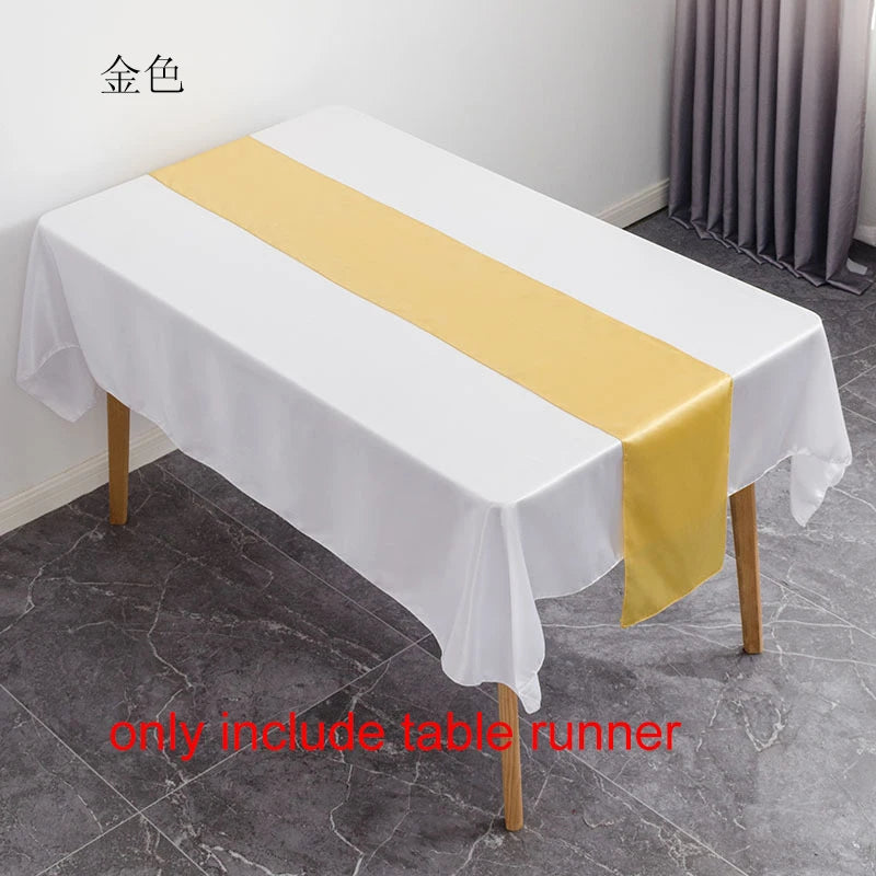 Elegant gold satin table runner draped across a white tablecloth for an event setting.