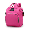 A pink insulated canvas mummy diaper bag with a black strap and hanging hook.