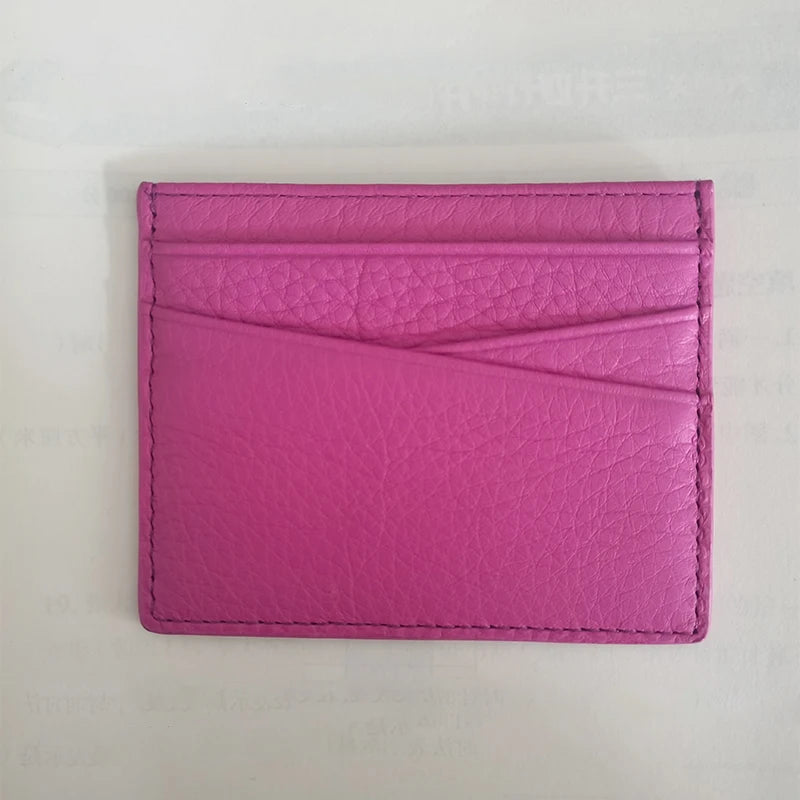 A pink genuine leather slim card holder wallet with a folded design.