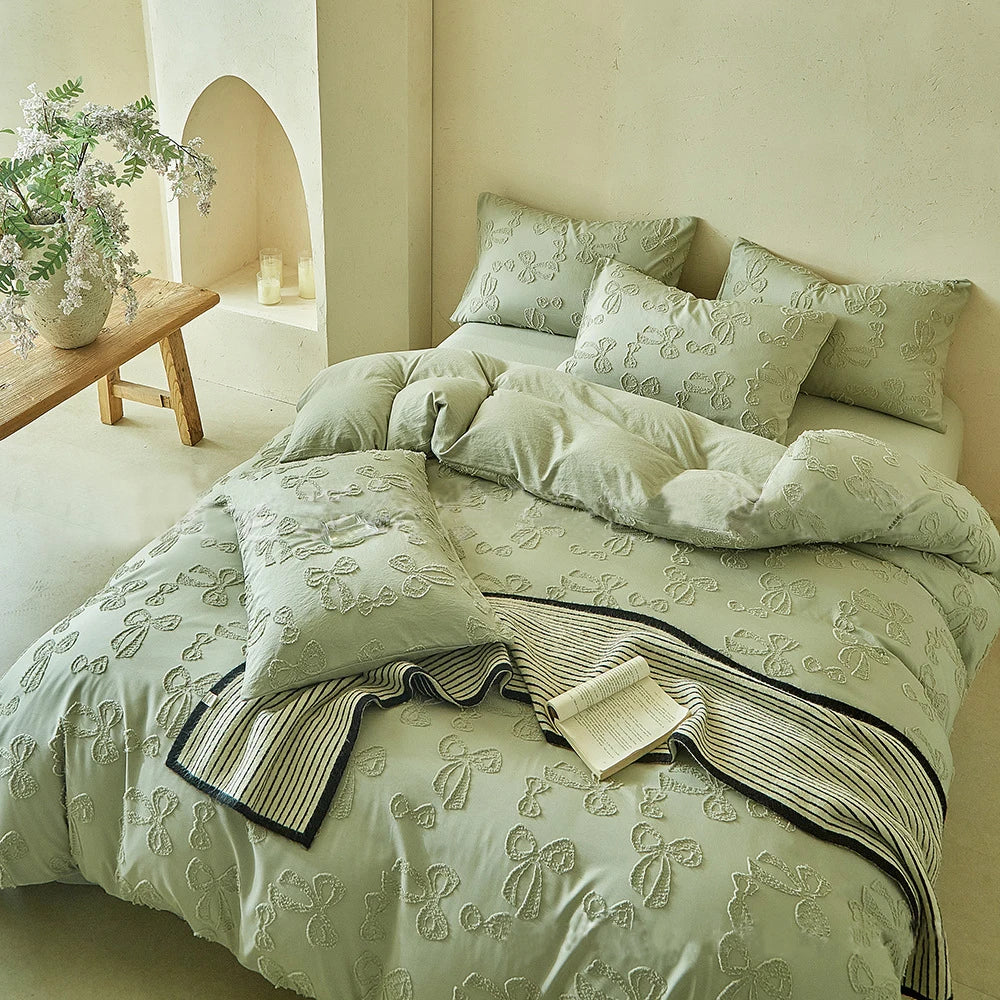 A light green Nordic leaf print duvet cover set displayed on a bed with pillows and a wooden stool in a bright room.