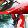 A hand is applying an automotive rubber sealing strip to a red car's window frame.