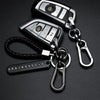 A silver phone number keychain featuring a digital display and attached to a braided black leather rope.