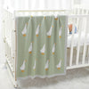 A soft cotton baby swaddle blanket with a light green background featuring a repeating pattern of small white cartoon birds.