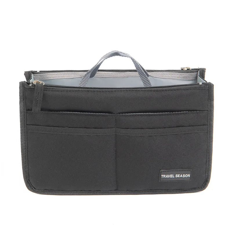 A black purse organizer insert with multiple compartments and a handle.
