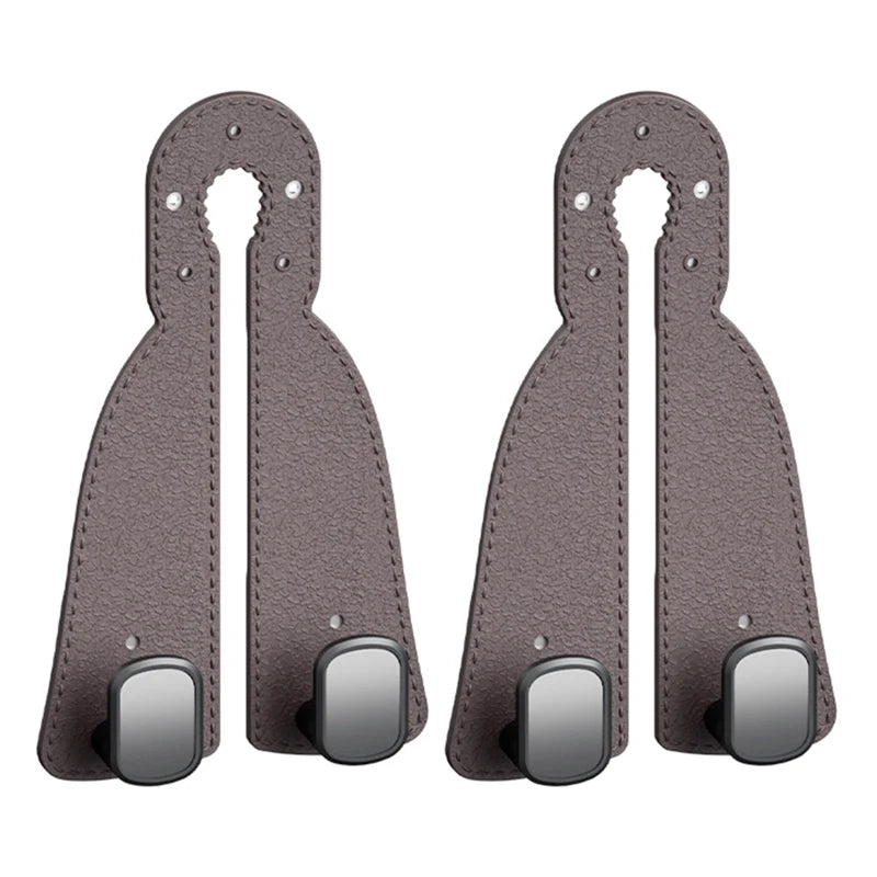 A pair of dark gray leather headrest hooks designed as a tidy organizer for bags, groceries, and coats.