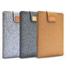Three felt laptop sleeves in gray, charcoal, and tan with leather accents.