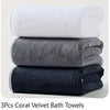 Three stacked coral velvet bath towels in white, gray, and navy blue.