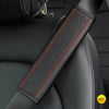 Close-up of a black PU leather embossed seat belt shoulder cushion with red stitching on a vehicle seat.
