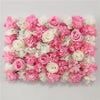 A dense wall panel of pink and white silk rose flowers for weddings and events.