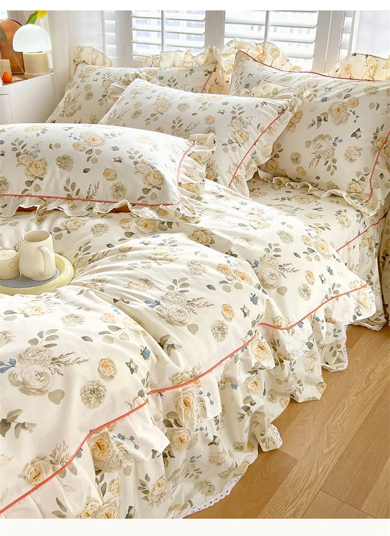 A set of floral ruffle cotton duvet covers in cream and beige tones displayed on a bed.