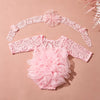 Pink lace newborn princess tutu dress romper with matching headband laid flat on a beige background