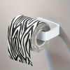 A roll of black and white zebra-print toilet paper is mounted on a white wall holder.