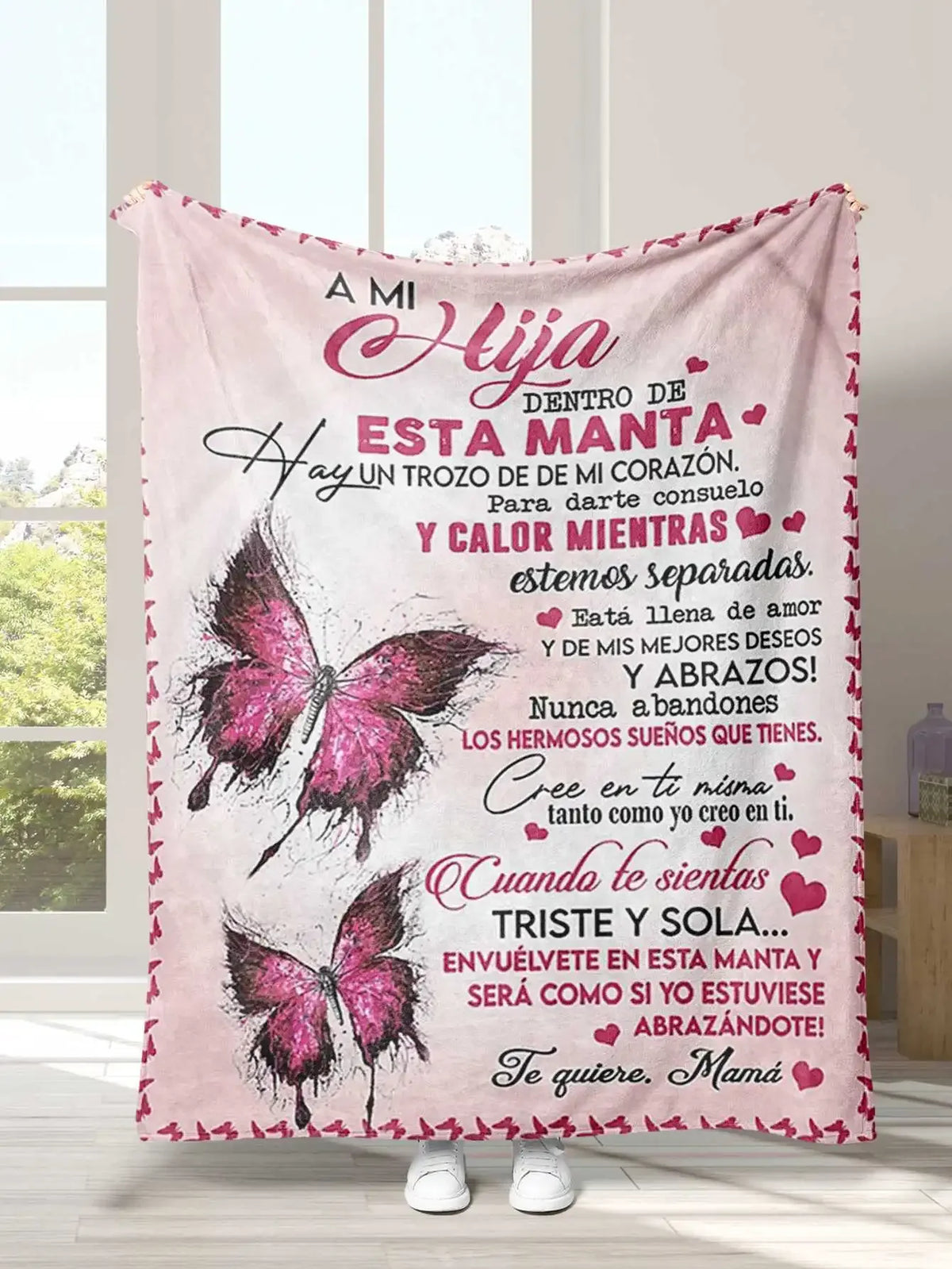 A pink flannel throw blanket featuring Spanish text about love and comfort for a daughter, son, or granddaughter