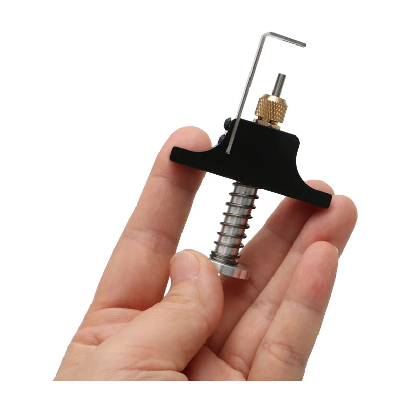 A hand holds a black tool with an ejector pin kit and a metal rod for removing tiny whoop propellers.