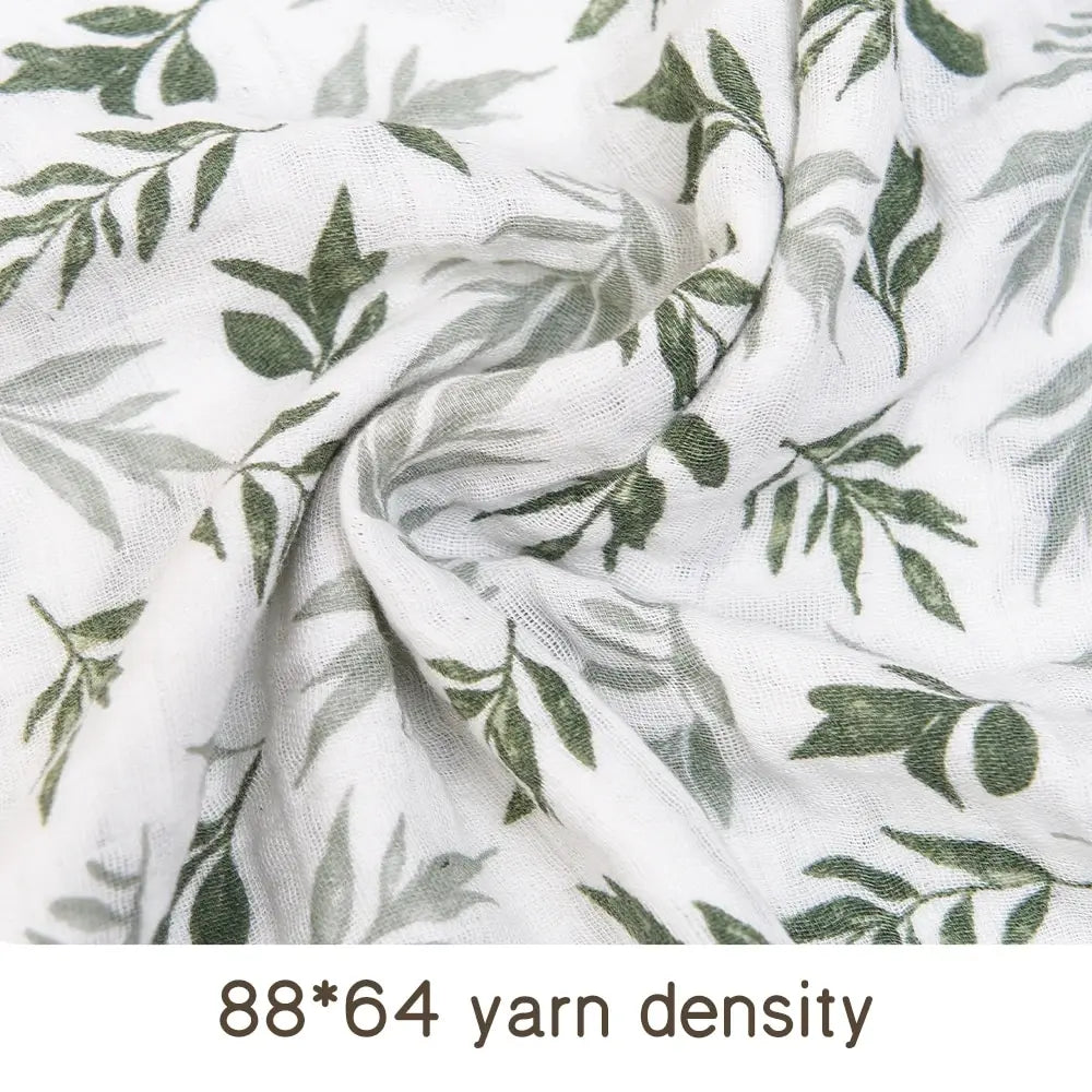 Close-up of white muslin fabric with a green leaf pattern, showing the yarn density.