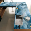 A kitchen countertop featuring blue marble peel-and-stick wallpaper with gold veining and a stainless steel sink.
