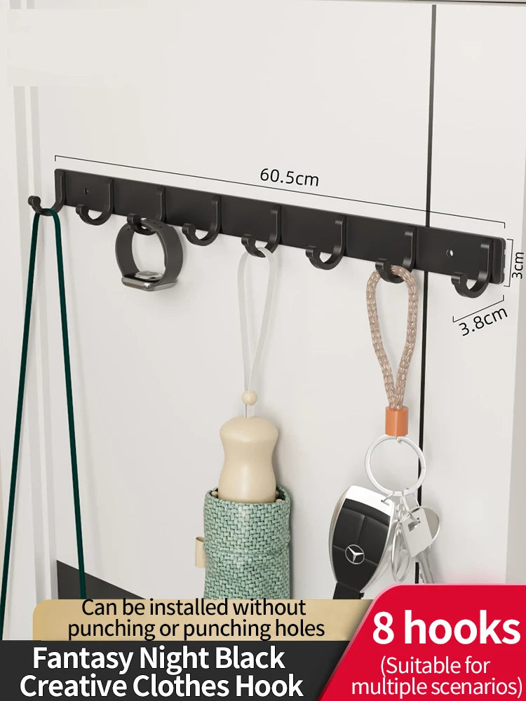 Black fantasy night clothes hooks with adhesive backing installed on a white wall