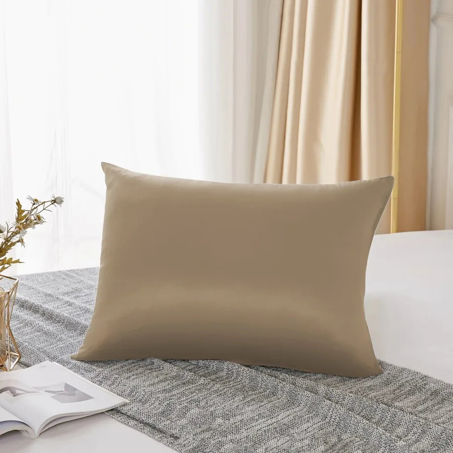 Housse de couette en soie naturelle mulberry beige posée sur un tissu en lin gris près d'une fenêtre.