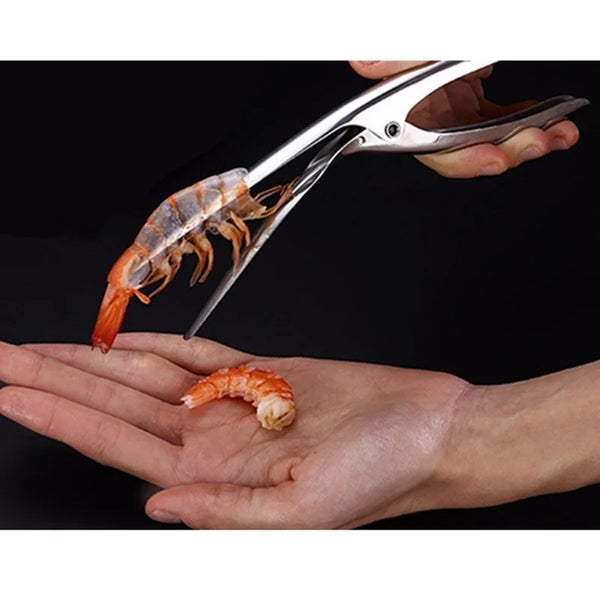 A hand holds a stainless steel shrimp peeler and is using it to peel a cooked shrimp.